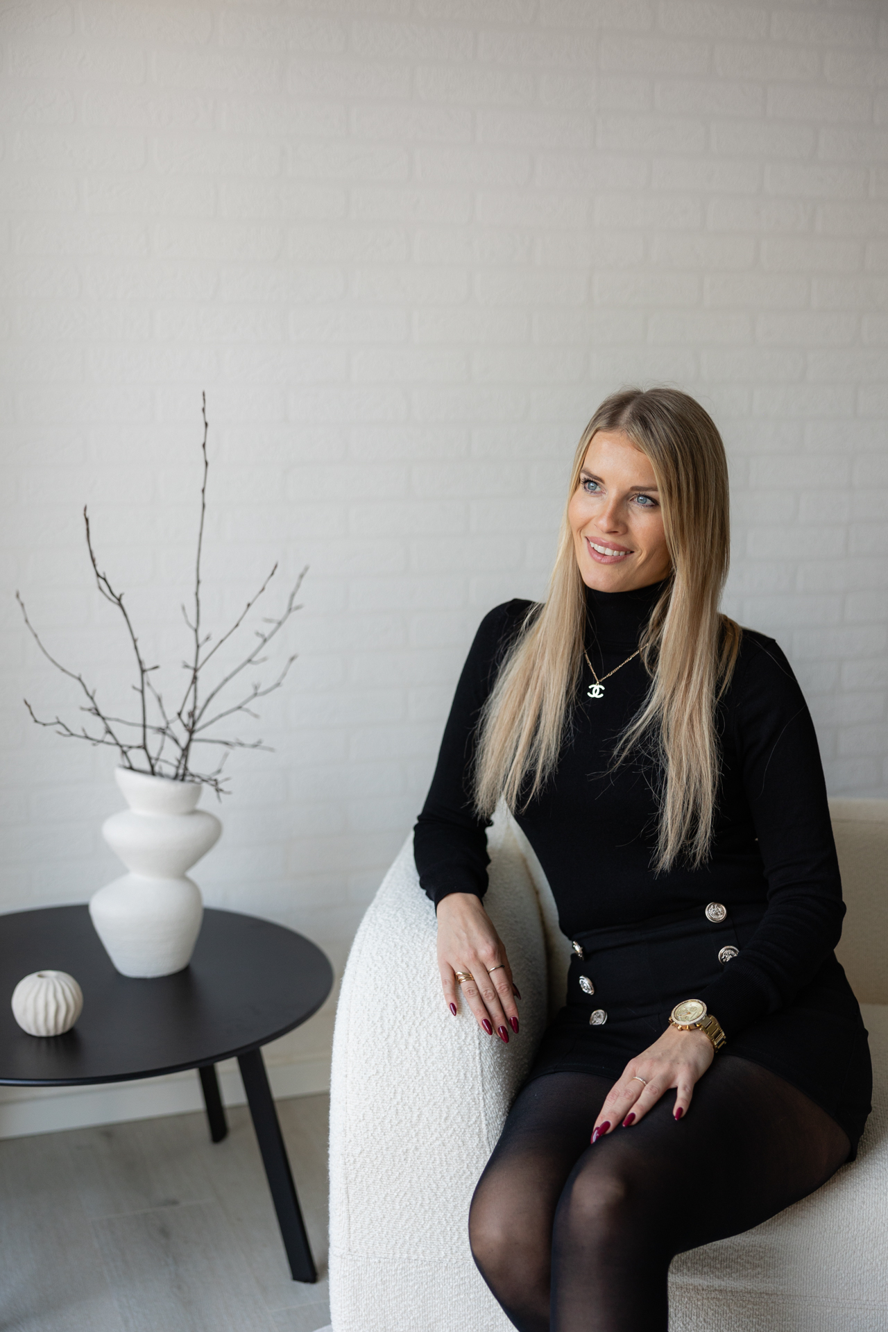 Blonde Frau mit schwarzer moderner Business Kleidung in einem hellen Modernen Umfeld. 