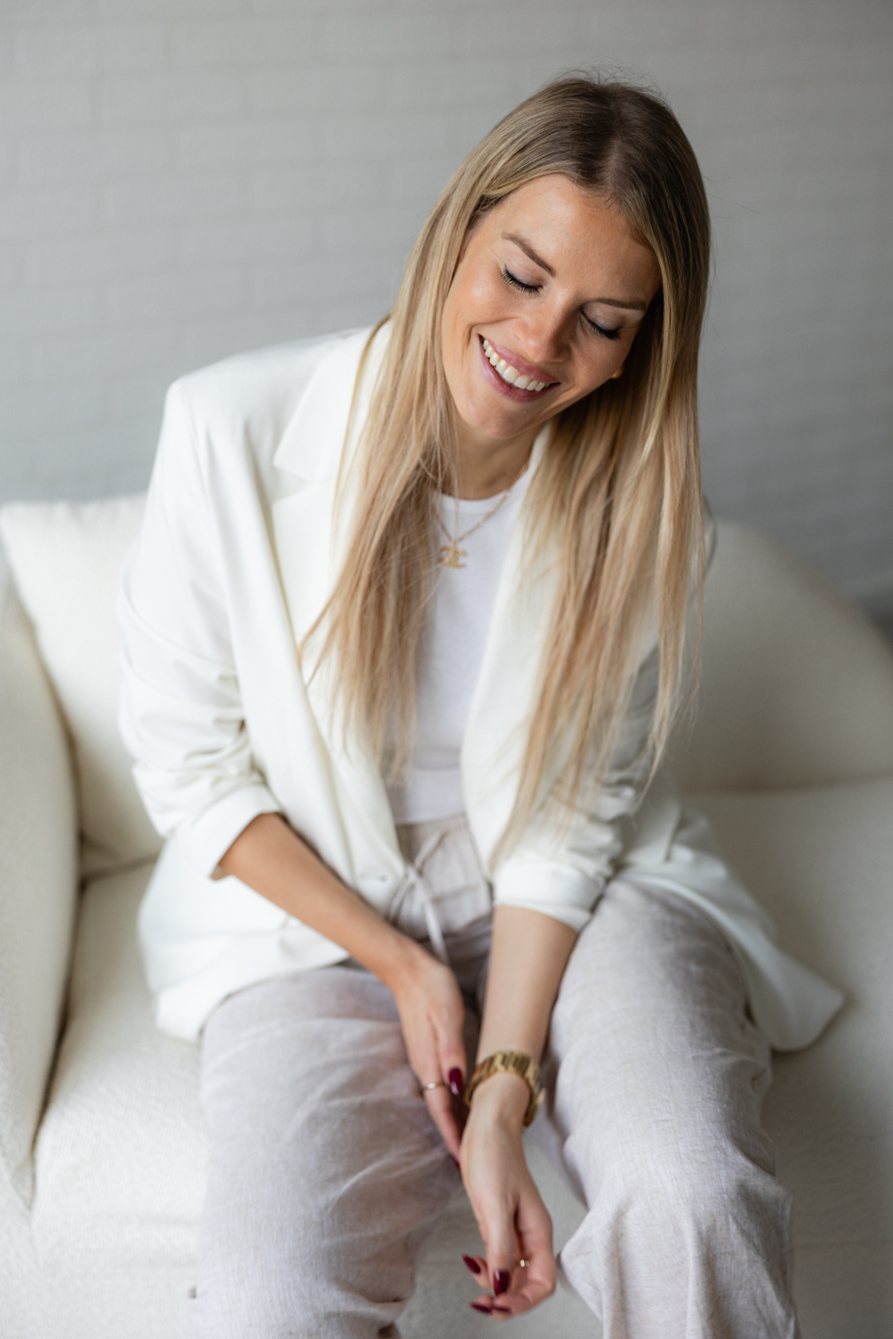 Lachende Frau in weißem Business Blazer in einem modernen hellen Umfeld